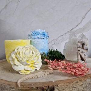 May include: A set of three ceramic mugs with a speckled, matte finish. Each mug features a different color: light blue, cream, and gray. The mugs have a simple, modern design with a rounded shape and a comfortable handle.