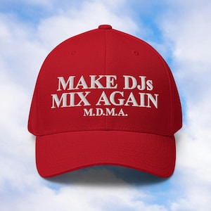 Op de afbeelding: Rode baseballpet met witte geborduurde tekst die "Make DJs Mix Again" en "M.D.M.A." luidt.