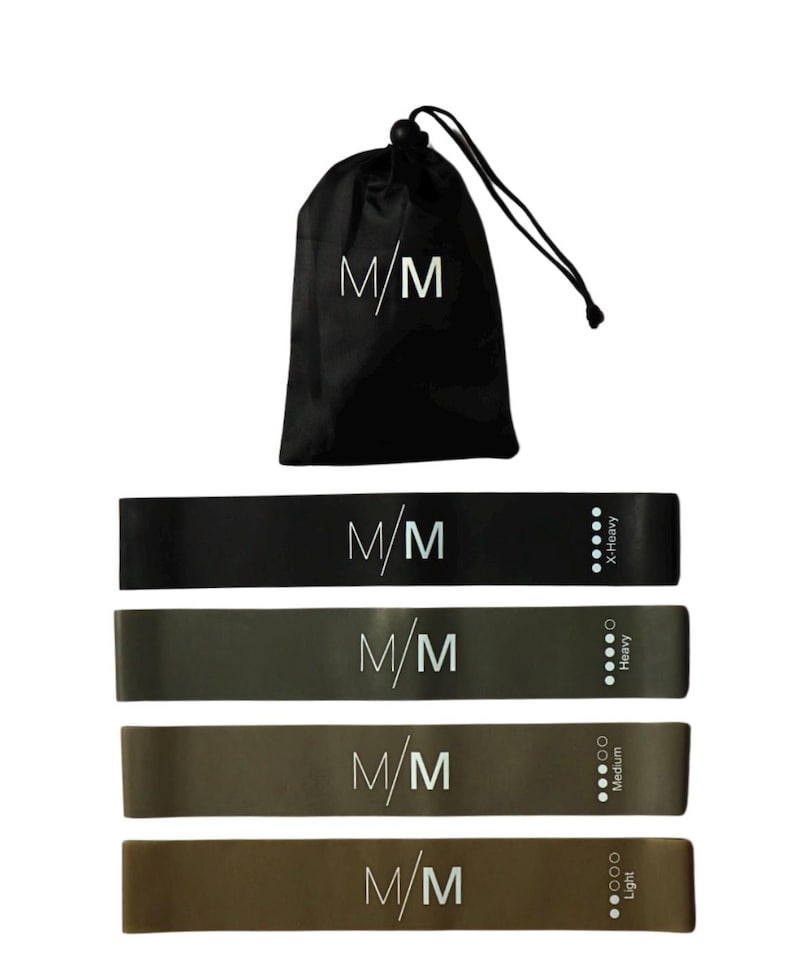 Puede incluir: Conjunto de cuatro bandas de resistencia en negro, verde oscuro, marr&oacute;n claro y marr&oacute;n, con el texto "M/M" impreso en cada banda. Las bandas est&aacute;n etiquetadas con su nivel de resistencia: Light, Medium, Heavy y X-Heavy. Las bandas est&aacute;n empaquetadas en una bolsa de cord&oacute;n negro con el texto "M/M" impreso en ella.