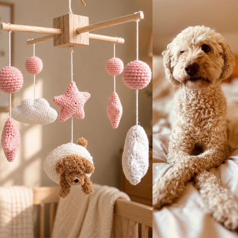 Puede incluir: Un m&oacute;vil de madera con elementos de ganchillo que incluyen esferas rosas, nubes blancas, estrellas rosas y una figura de perro marr&oacute;n suspendidos por hilos blancos de un marco de madera, junto a un perro marr&oacute;n claro sentado en una cama.