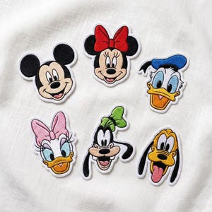 May include: Embroidered patches featuring Mickey Mouse, Minnie Mouse, Donald Duck, Daisy Duck, Goofy, and Pluto. Each patch has a white border and showcases the characters' iconic designs and colors. Perfect for adding to clothing or accessories.