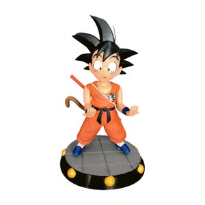 Puede incluir: Figura de un personaje de Dragon Ball Z. La figura lleva un atuendo naranja con un cinturón negro y zapatos azules. El personaje tiene el pelo negro puntiagudo y está de pie sobre una plataforma gris con detalles amarillos.