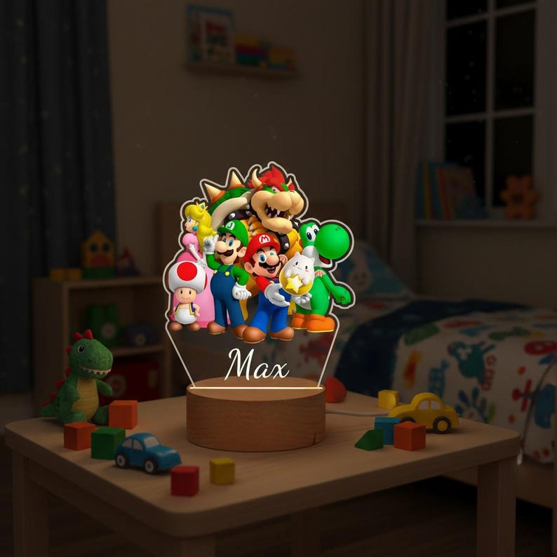 May include: A night light featuring a group of colorful characters from the Super Mario video game series. The light has a wooden base and a clear acrylic top with the name "Max" engraved on it. The characters include Mario, Luigi, Yoshi, and Bowser.