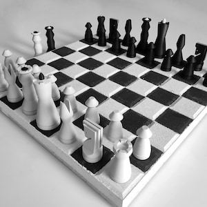 Op de afbeelding: Een zwart-wit schaakspel met een dambordpatroon. De schaakstukken zijn op het bord geplaatst, klaar voor een spel. Het bord is vierkant en de stukken hebben een klassiek ontwerp.