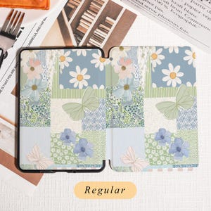 May include: A patterned tablet case with a floral and butterfly design. The case features a patchwork of blue, green, and white squares with daisies, butterflies, and floral patterns. The word "Regular" is printed on a yellow label.