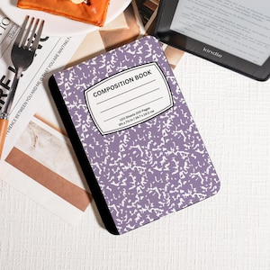 Könnte beinhalten: Ein lilafarbenes Notizbuch mit weißem Sprenkelmuster. Der Einband trägt die Aufschrift "COMPOSITION BOOK" und gibt die Maße mit 24,7 x 19,0 cm an. Das Buch hat 100 Blatt und 200 Seiten.