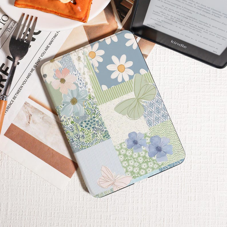 May include: A Kindle case with a patchwork design featuring daisies, butterflies, and floral patterns in pastel colors. The case has a mix of blue, green, and pink hues, creating a whimsical and artistic look. The case is designed to protect the Kindle.