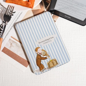 Peut inclure: Une housse de Kindle à rayures bleues et blanches, avec un singe de dessin animé versant du sirop sur des crêpes. La housse porte l'inscription "Do everything in love. 1 Corinthiens 16:14". Un lecteur Kindle est visible.