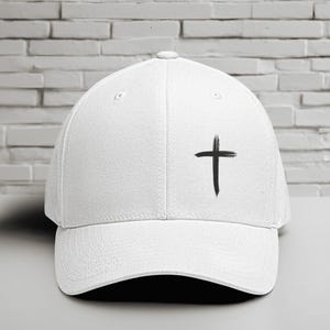 May include: A white baseball cap with a curved brim. The cap features a black cross design on the front. The cap is made of a durable fabric and has a classic, structured fit.