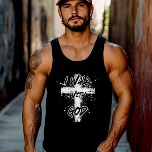 Könnte beinhalten: Schwarzes Tanktop mit weißem Kreuz-Grafik und dem Text "I WALK WITH GOD". Das Design hat einen Used-Look mit Spritzereffekt. Das Tanktop ist ärmellos und aus weichem Material.
