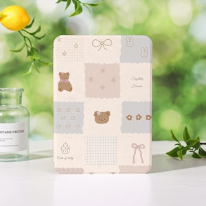 Pode incluir: Uma capa retangular em tons pastel com um design de patchwork com ursinhos de pelúcia, laços, corações, estrelas e motivos florais. O texto "Together Forever" e "Cake of daily" são visíveis. A capa tem uma borda arredondada.