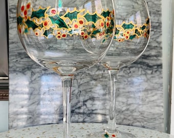 Juego de dos copas de vino navideñas pintadas a mano, con diseño de acebo y bayas.