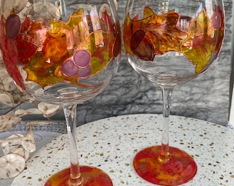 Juego de dos copas de vino otoñales pintadas a mano con diseño de hojas y bellotas. Temporada de otoño.