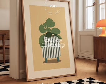 Op de afbeelding: Een groot ingelijst kunstwerk met een botanische illustratie van een plant in een pot. De print heeft een beige achtergrond en zit in een houten lijst. De woorden "frame-mockup" staan in het midden van de print. De lijst leunt tegen een muur.