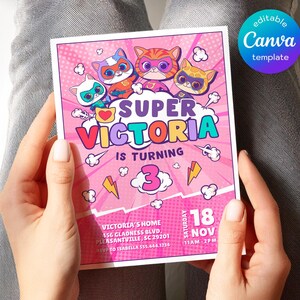 May include: A pink birthday invitation featuring four cartoon superhero cats. The invitation reads "SUPER VICTORIA IS TURNING 3" with additional details including the date, time, and location. The Canva template is held by a person.