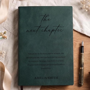 May include: A dark green rectangular journal with the text The next chapter in elegant script, followed by a paragraph of text and the name AMELIA SMITH printed in black. The cover has a smooth, matte texture and a clean, professional appearance.