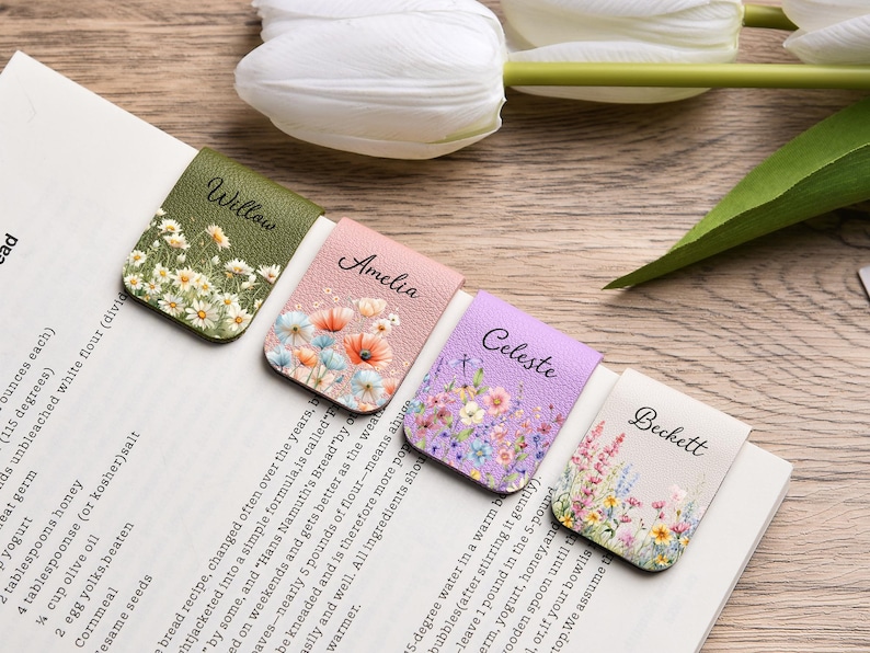May include: Four rectangular magnetic bookmarks with textured surfaces, each featuring a unique floral print and a name printed in black script: Willow on olive green, Amelia on light pink, Celeste on lavender, and Beckett on cream.