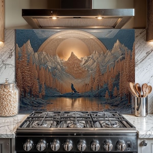 Puede incluir: Salpicadero de cocina decorativo con un paisaje montañoso, un lobo aullando y una luna dorada. La obra de arte utiliza tonos azules, marrones y dorados. Instalado detrás de una estufa de gas negra.