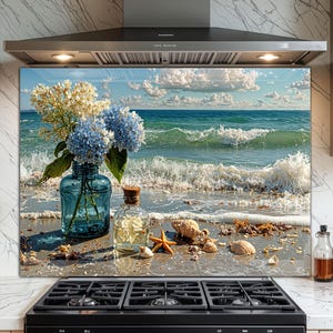 Puede incluir: Un protector contra salpicaduras de cocina que representa una escena de playa con flores azules y blancas en un jarrón de vidrio azul, una pequeña botella de vidrio, conchas marinas y una estrella de mar. Las olas del océano y el cielo nublado son visibles en el fondo.