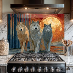 Puede incluir: Un protector contra salpicaduras de cocina decorativo con una imagen de mosaico de tres lobos. La obra de arte presenta una cálida paleta de colores con un gran sol naranja y un fondo de bosque. Los lobos están representados en tonos grises, beige y marrón.