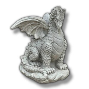 May include: A detailed, light gray dragon statue with large, textured wings and a scaled body. The dragon is seated on a stone base, with its head held high. This decorative statue is suitable for indoor or outdoor display.