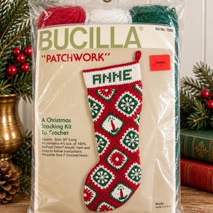 May include: A Bucilla Patchwork Christmas stocking kit in a clear plastic package. The kit includes red, white, and green yarn and instructions to crochet a 20-inch long stocking featuring a patchwork pattern of snowflakes and candles.