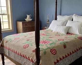 May include: A bedroom with a four-poster bed featuring a floral quilt in shades of beige, pink, and green. The room has blue walls, a wooden floor, and a wooden dresser. White pillows adorn the bed.