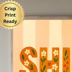 May include: A framed art print with the word "SHINE" in orange, floral-decorated letters. The background features vertical stripes in light orange and white. A gold seal with the text "Crisp Print Ready" is in the upper left corner.