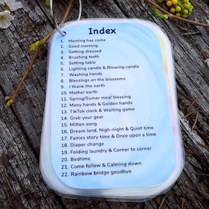 May include: A blue and white laminated card with the word "Index" at the top. The card lists 22 activities with corresponding numbers. The card is lying on a wooden surface with flowers.