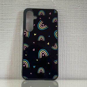 May include: Black phone case with a pattern of colorful rainbows and pink hearts.