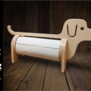May include: Wooden dachshund-shaped paper towel holder. The holder is made of light-colored wood and features a roll of white paper towels. The design includes a tail, head, and legs, creating a playful and functional kitchen accessory.