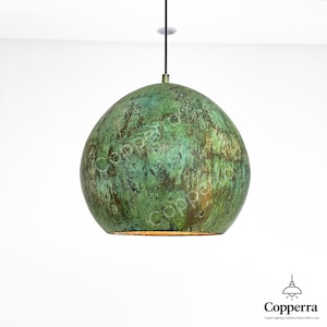May include: A green, round, copper pendant light fixture with a textured surface. The light is hanging from a black cord.