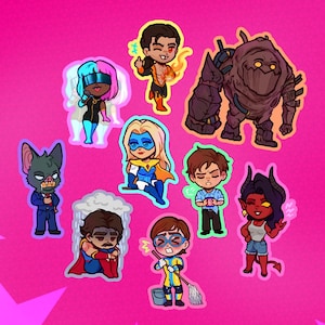 Puede incluir: Una colección de pegatinas de dibujos animados coloridos con varios personajes de superhéroes y fantasía. Las pegatinas están sobre un fondo rosa brillante con acentos de estrellas. Cada personaje tiene un diseño y esquema de color únicos.