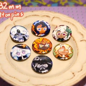 Peut inclure: Sept badges de 32 mm avec des illustrations de personnages de dessins animés, disposés sur une assiette crème. Les badges présentent divers personnages avec des designs et des couleurs uniques. Le fond est violet à motifs.