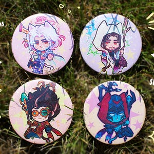 Könnte beinhalten: Vier 75-mm-Knopf-Anstecknadeln mit Illustrationen von Anime-Charakteren. Jeder Pin zeigt einen anderen Charakter in leuchtenden Farben mit einem glänzenden Holo-Star-Effekt. Die Pins sind vor einem Hintergrund aus grünem Gras angeordnet.