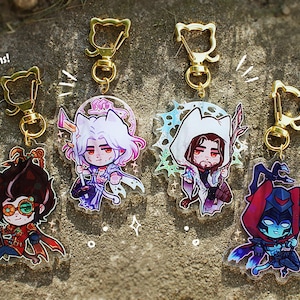 Könnte beinhalten: Fünf Acryl-Schlüsselanhänger mit Anime-Charakter-Designs, jeweils mit einem goldfarbenen, katzenförmigen Verschluss. Die Schlüsselanhänger sind 63,5 mm groß. Die Charaktere sind in verschiedenen Outfits und Posen dargestellt.