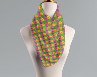 May include: A green scarf with a repeating pattern of pink and yellow flowers.