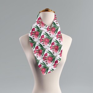 Könnte beinhalten: Ein weißes Bandana mit einem rosa-grünen Blumenmuster. Das Bandana zeigt ein sich wiederholendes Muster aus rosa Blüten und grünen Blättern.