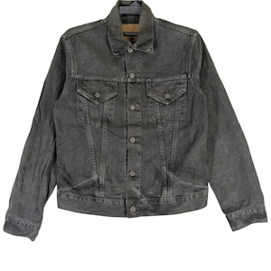 May include: A faded black denim jacket with a classic design. The jacket features a button-up front, two chest pockets with button flaps, and two side pockets. The collar is a traditional fold-down style. The jacket is made of a durable denim material.