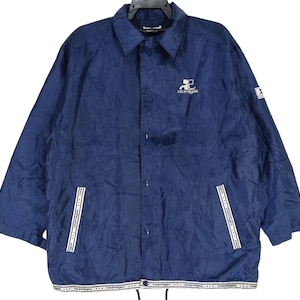 May include: A navy blue jacket with a white zipper and white trim. The jacket has a logo on the left chest that says "Coors Light".
