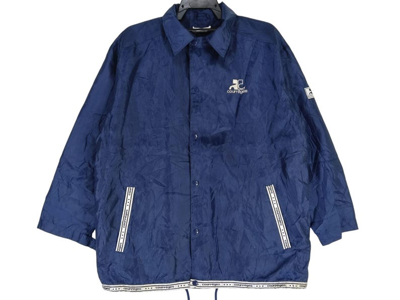 May include: A navy blue jacket with a white zipper and white trim. The jacket has a logo on the left chest that says "Coors Light".