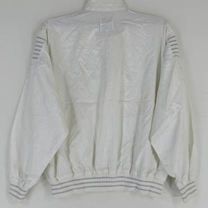 May include: White vintage jacket with a high collar and long sleeves. The jacket has a textured pattern and gray stripes on the cuffs and hem. The back view shows the full design.