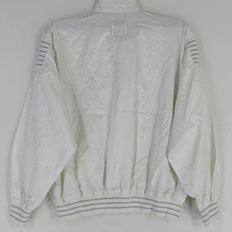 May include: White vintage jacket with a high collar and long sleeves. The jacket has a textured pattern and gray stripes on the cuffs and hem. The back view shows the full design.