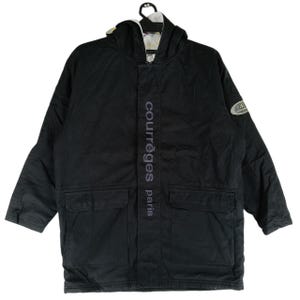 May include: Black hooded jacket with the text "courr&egrave;ges paris" vertically down the front. The jacket has two front pockets and a logo patch on the sleeve. The jacket is hanging on a black hanger.