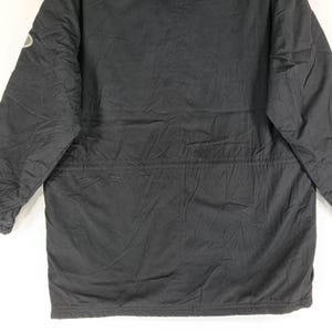 May include: Black winter coat with a quilted design. The coat has a drawstring waist and a small logo on the upper left sleeve. The coat is made of a durable, weather-resistant material.