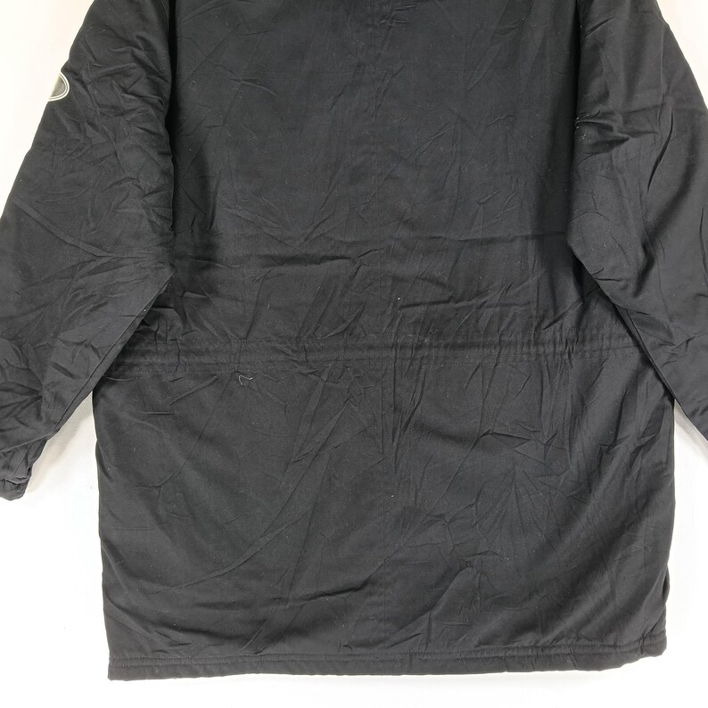 May include: Black winter coat with a quilted design. The coat has a drawstring waist and a small logo on the upper left sleeve. The coat is made of a durable, weather-resistant material.