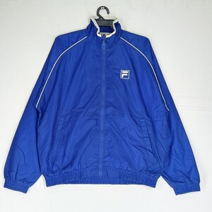 May include: A royal blue zip-up jacket with white trim and a white collar. The jacket features a small white square logo on the chest. The jacket is hanging on a black hanger.