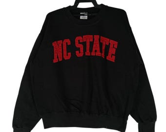 Sudadera vintage negra grande de NC State, suéter con bordado de NC State, suéter de cuello redondo, sudadera con texto "Deletrear NC State", talla L