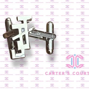 May include: Silver cufflinks with a geometric design. The cufflinks are in the shape of a letter 'H' with a small bar across the top. The cufflinks are on a white background.