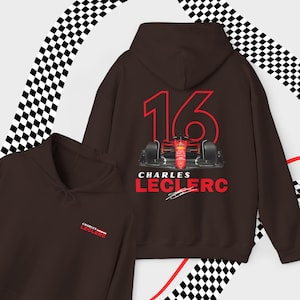 Puede incluir: Una sudadera con capucha marr&oacute;n con un gr&aacute;fico de coche de carreras rojo y blanco en la parte posterior. El coche tiene el n&uacute;mero 16 y el texto "Charles Leclerc" debajo. La sudadera tambi&eacute;n tiene un peque&ntilde;o logotipo en la parte delantera con el texto "Charles Leclerc".